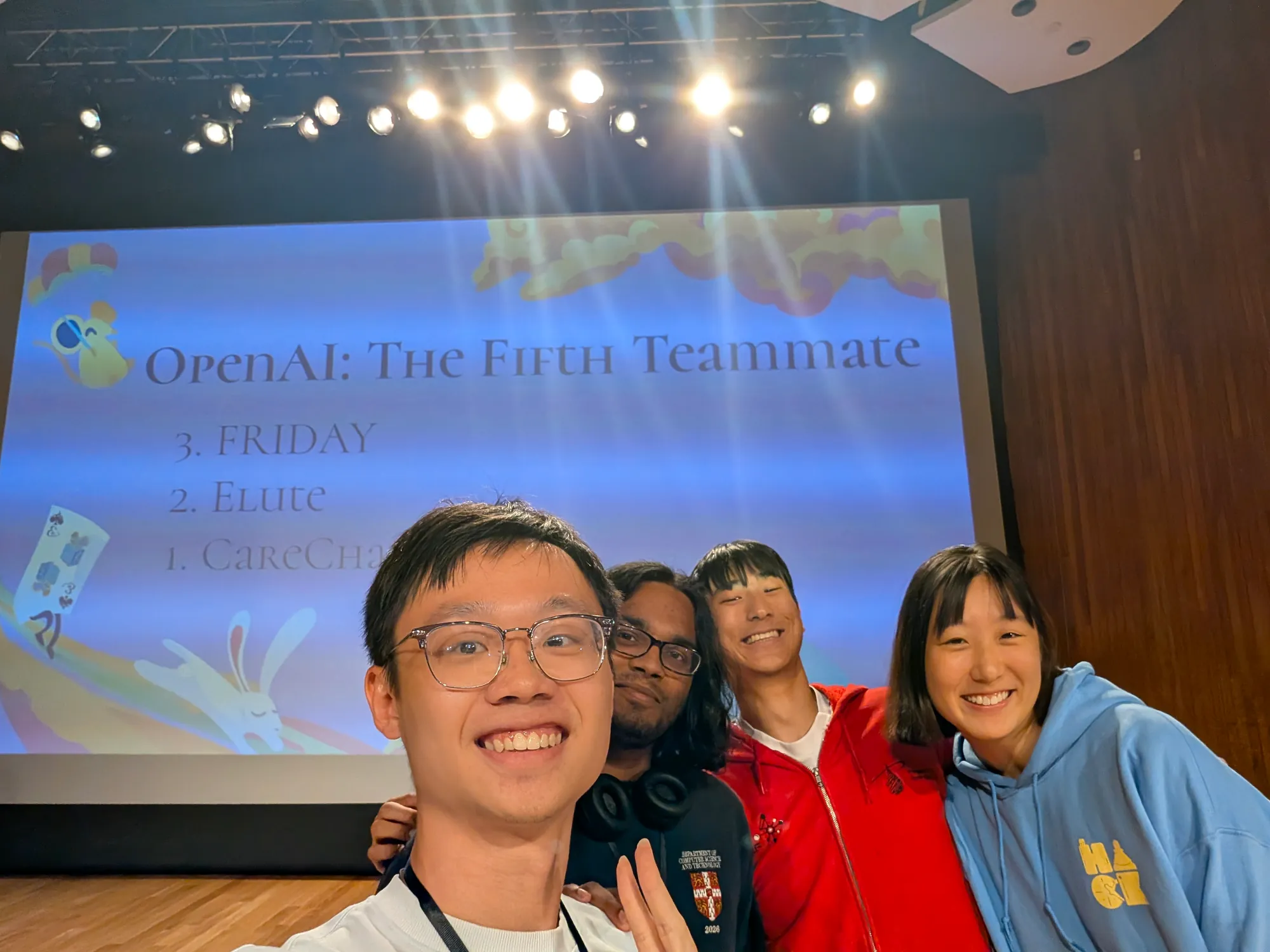 A group selfie under the slide “OpenAI: The Fifth Teammate”, which lists FRIDAY third.