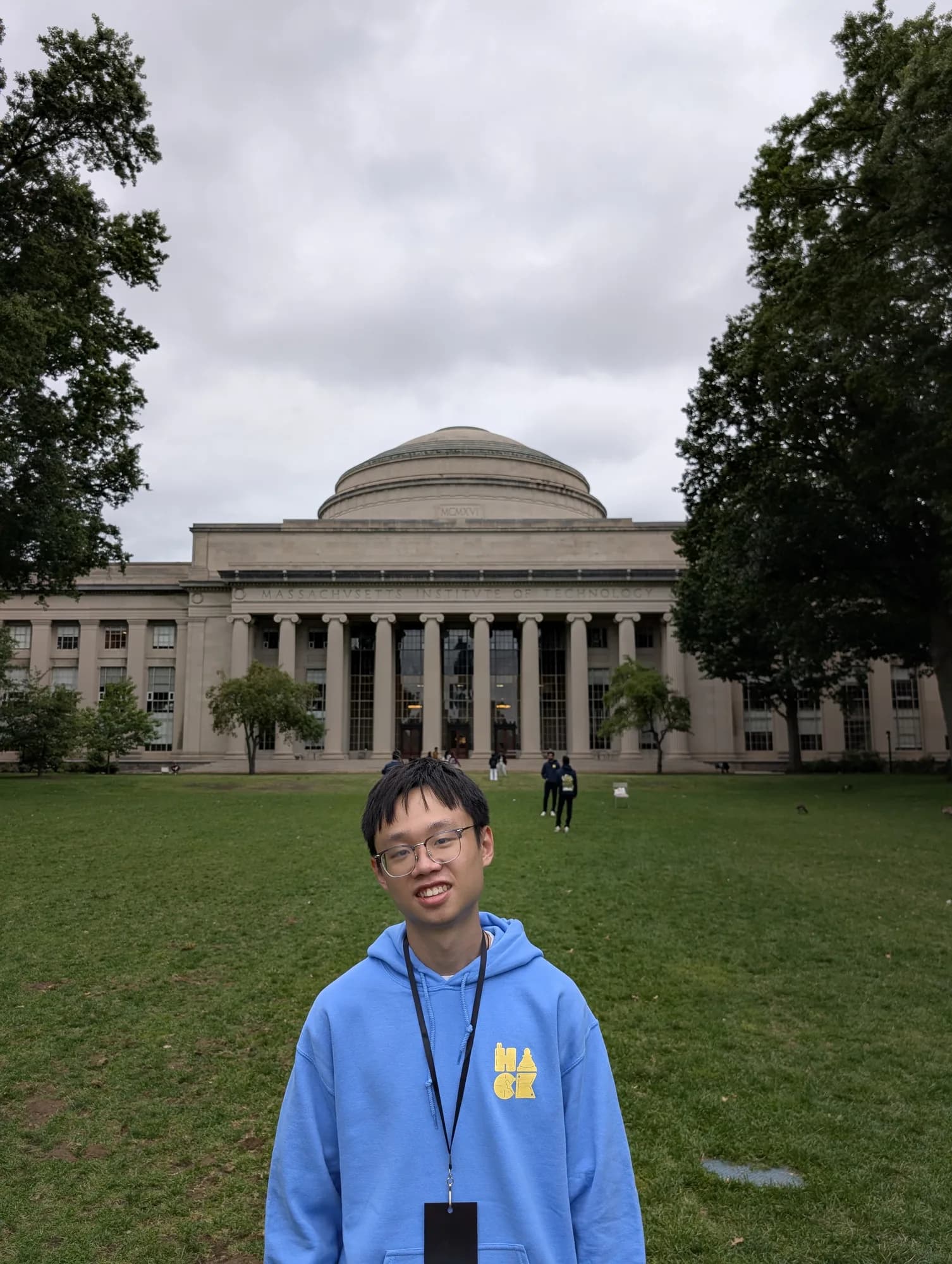 SL in a blue HackMIT hoodie on the lawn in front of MIT’s Great Dome.