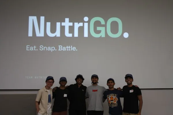 The NutriGo team in matching caps under the slide “NutriGO. Eat. Snap. Battle.”