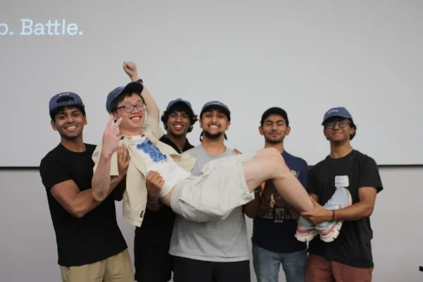 The NutriGo team lifting SL sideways in front of the projector screen.